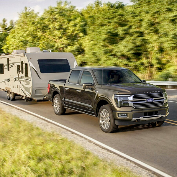 2024 Ford F-150® Platinum Plus in Agate Black pulling a camper trailer