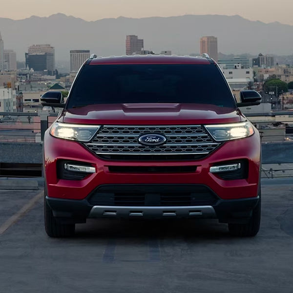 2024 Ford Explorer® Limited Hybrid model in Rapid Red Metallic Tinted Clearcoat on top of a parking structure