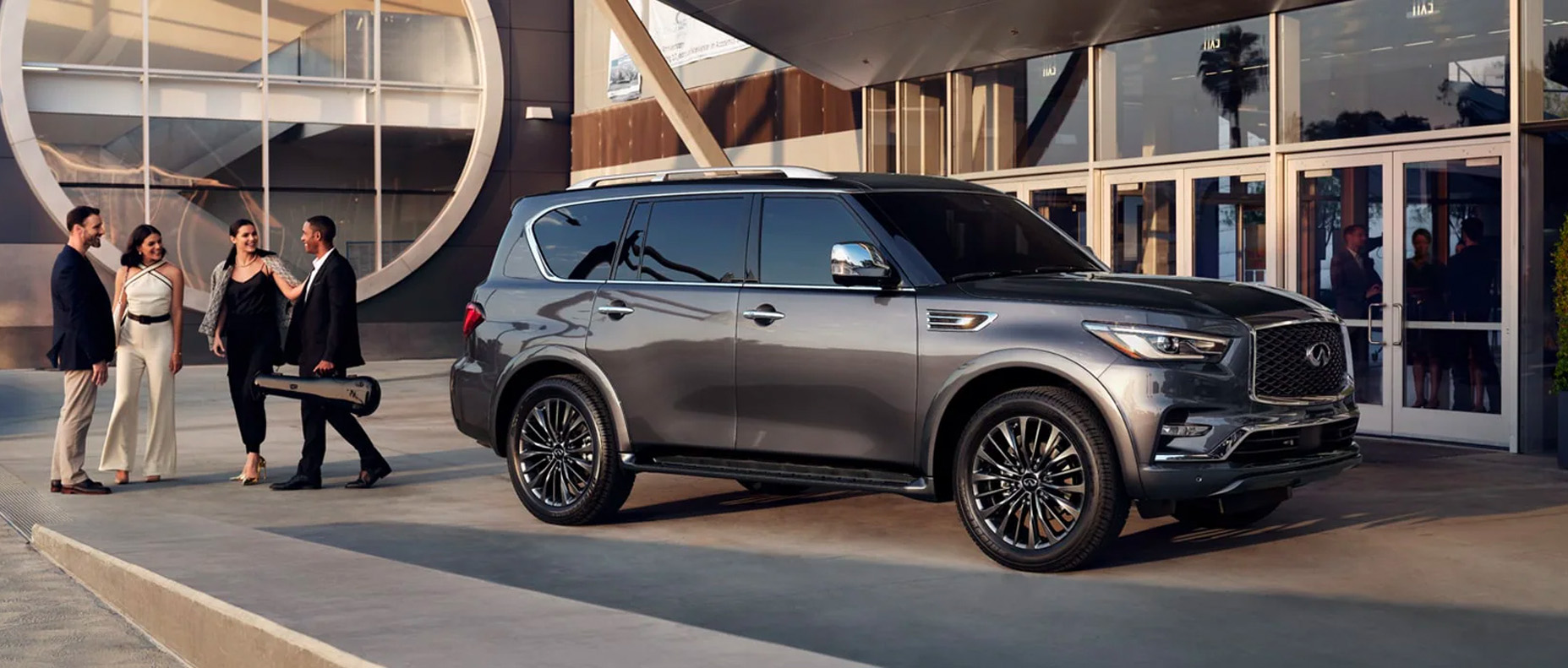2024 INFINITI QX80 parked outside a modern building