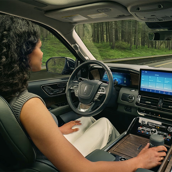 A driver of a 2024 Lincoln Black Label Navigator® SUV relaxes with hands-free driving technology engaged.