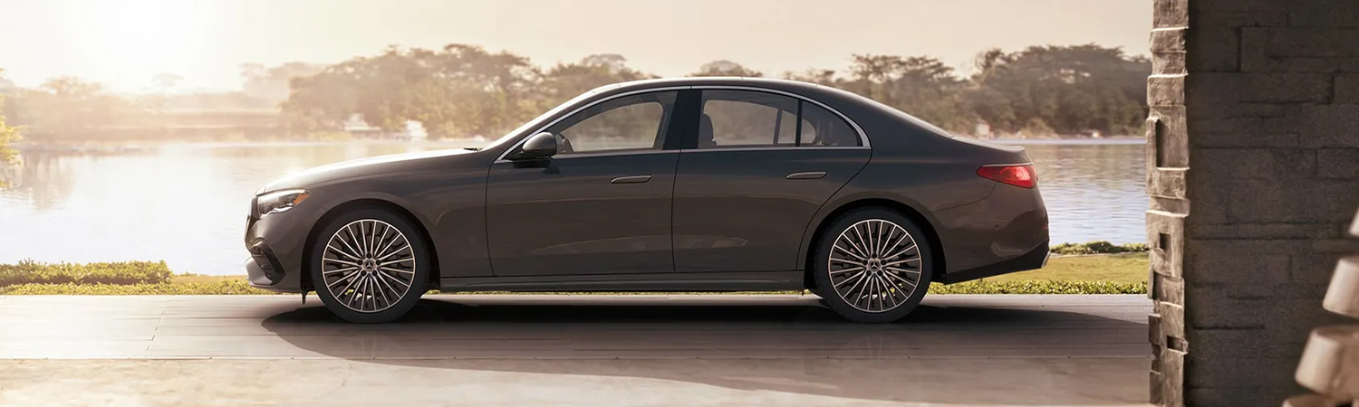 Side profile view of the 2024 E-Class sedan with a sunset in the background