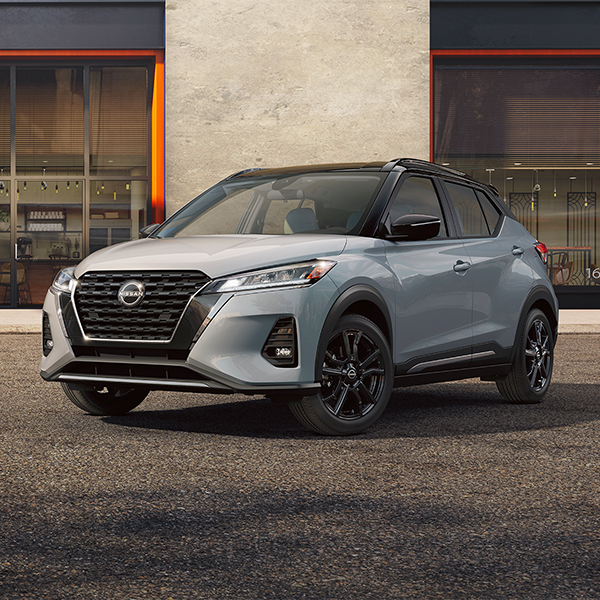 2025 Nissan Kicks parked in front of a modern building