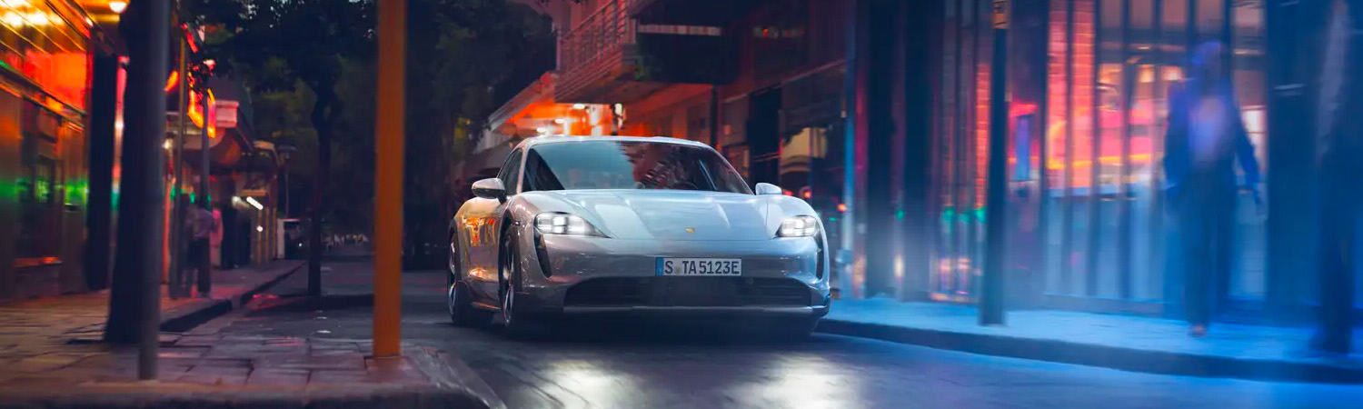 2024 Porsche Taycan driving through the city at night
