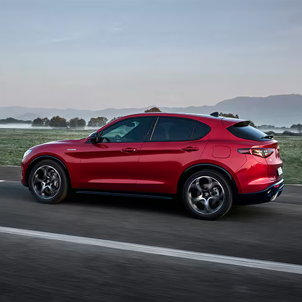 3/4 rear side view of the 2025 Alfa Romeo Stelvio in motion driving down the road