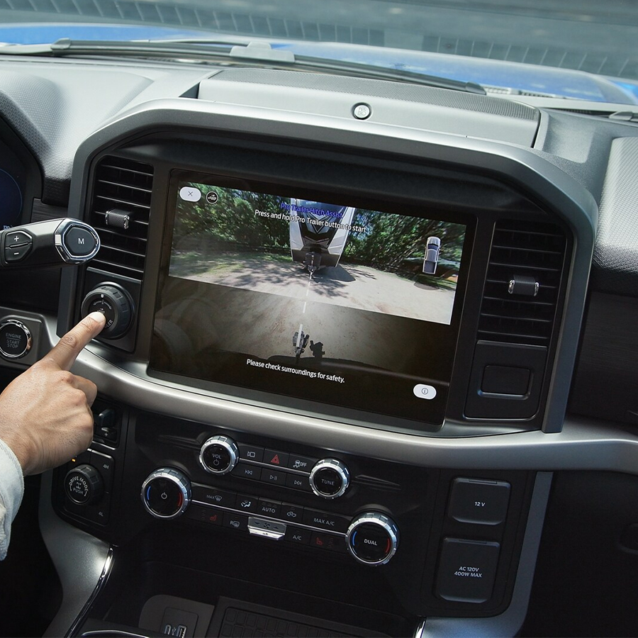 Man activates Pro Trailer Hitch Assist™ using the Pro Trailer knob inside a 2025 Ford F-150®