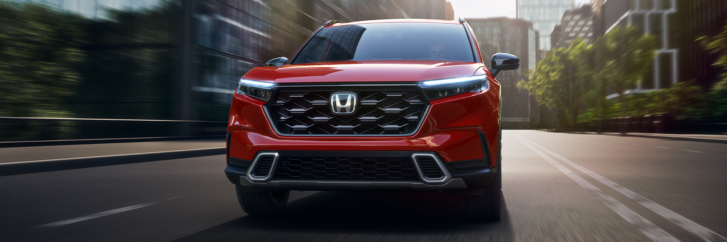 Front view of a Honda CR-V Hybrid driving through the city