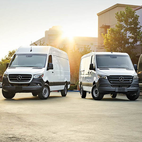 Two Sprinter Passenger Vans parked outside