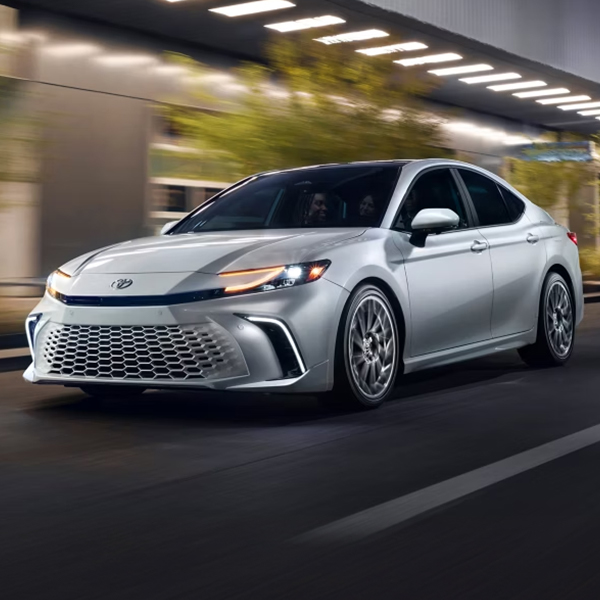 2025 Toyota Camry in motion driving through the city at night