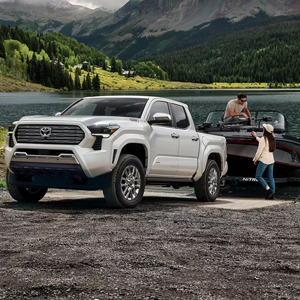 Two people attaching a boat to the 2025 Toyota Tacoma Hybrid
