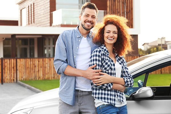 couple standing infront of vehicle