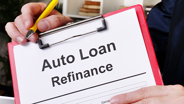 Auto loan refinance concept. The man offers to sign the document.