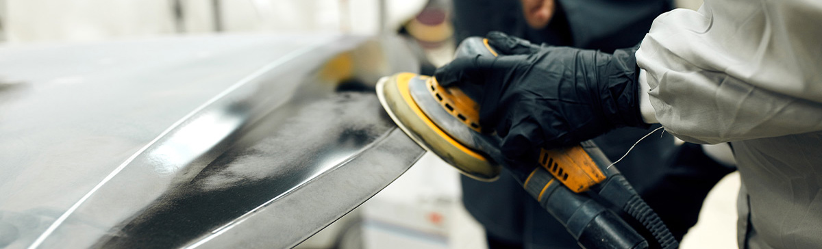 body shop tech buffing out a car