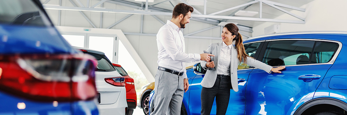 Dealership employee showing a customer a vehicle
