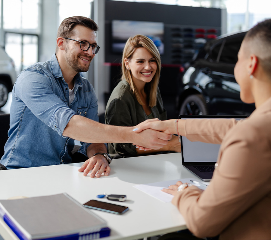 Dealership employee shaking hands with customer