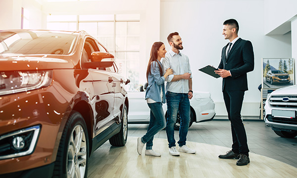 Dealership Employee speaking with customers on the floor