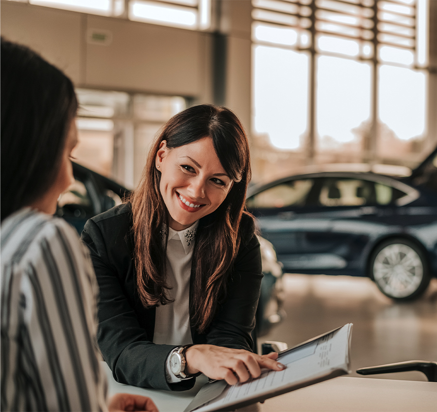 Dealership employee going over finance application with a customer