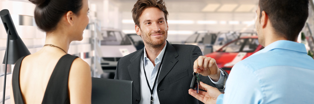 Dealer handing keys to customer