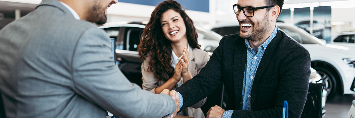 people at dealership buying a car