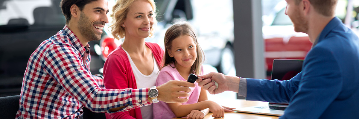 happy family getting new keys to their car