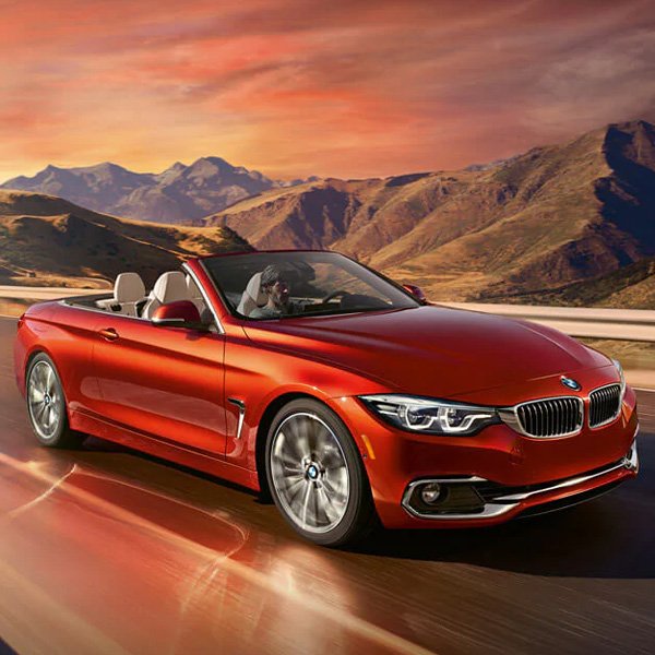 BMW convertible driving down road