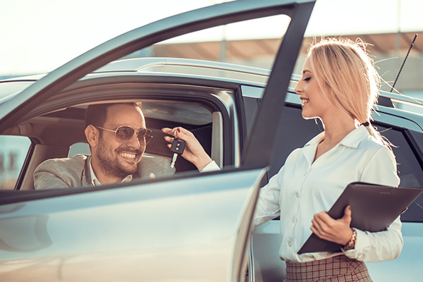 woman handing man car keys