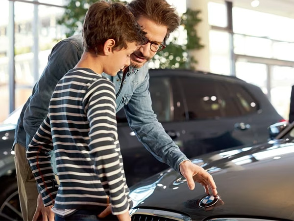 A father and son checkout a vehicle inside a BMW showroom