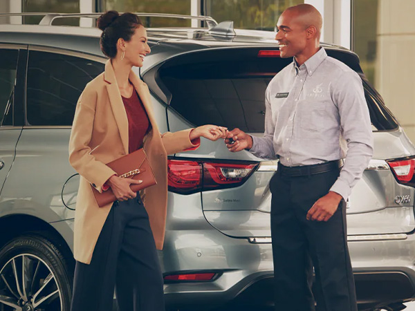 Woman Handing Her INFINITI Keys To INFINITI Maintenance Staff
