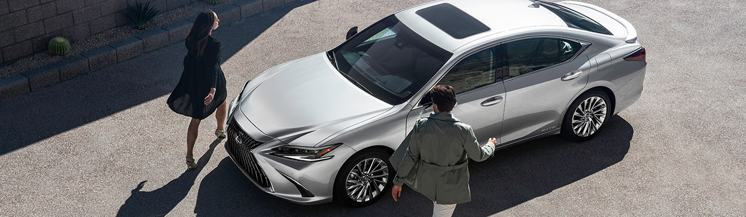 Two people walking up to their Lexus