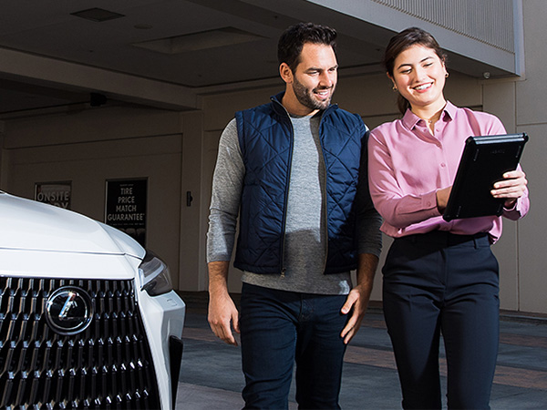 Woman showing a Lexus customer an iPad