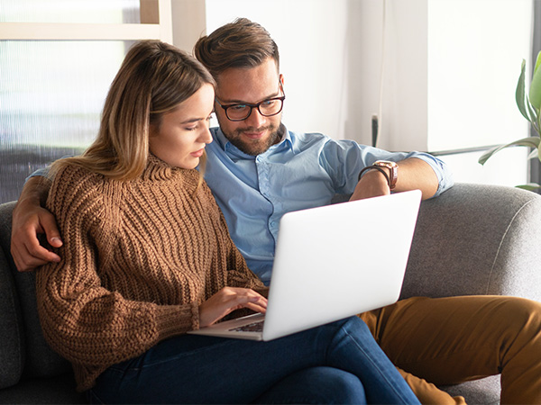 Happy couple looking at their laptop together