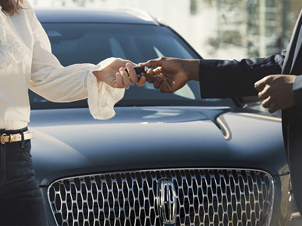 Customer handing over Lincoln Keys to a dealership employee