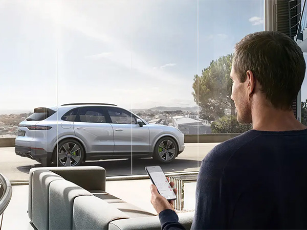Person on their phone with a porsche in the background
