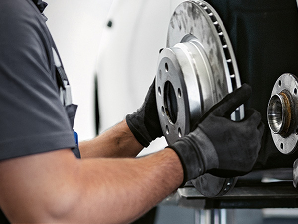 BMW service tech inspecting brakes