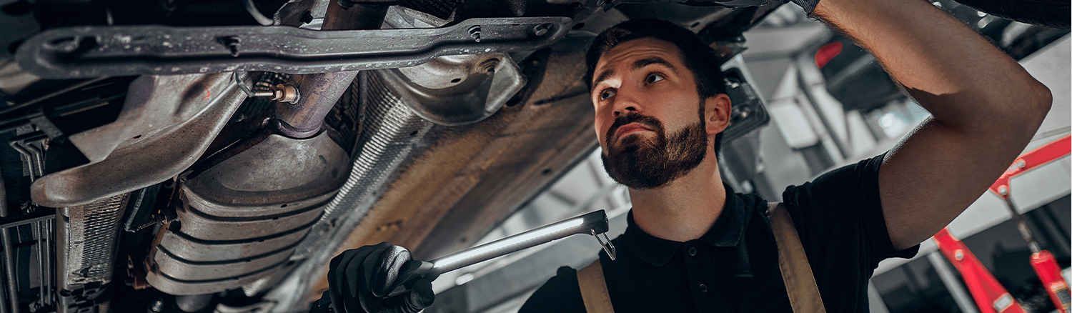 Service tech checking underneath a vehicle