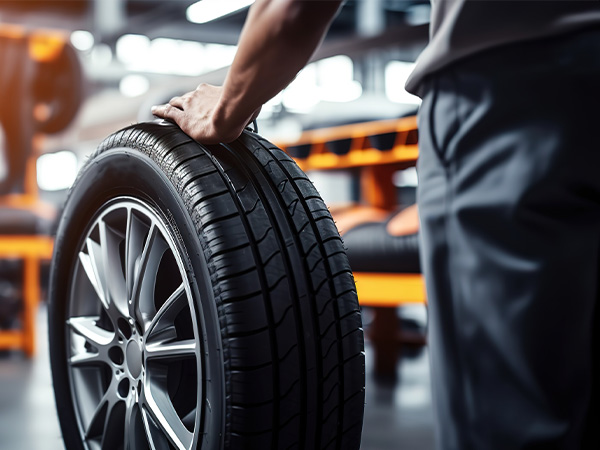 Close up of service tech rolling a tire through the service bay