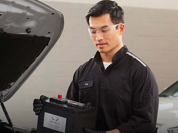 INFINITI service tech holding a battery