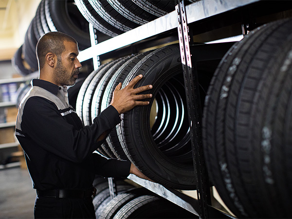 Lexus service tech pulling tires from the rack