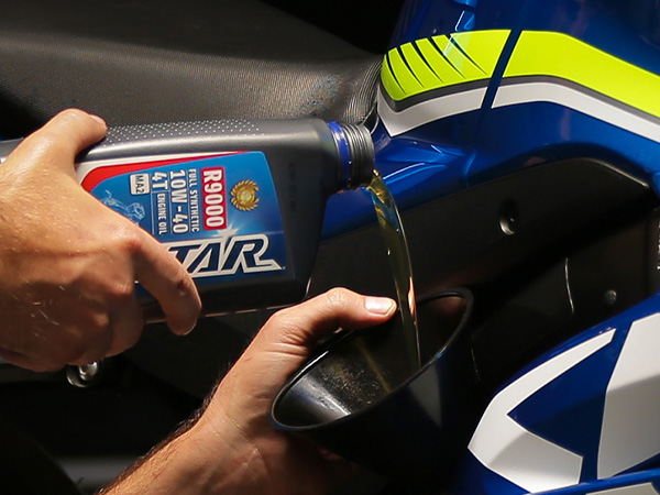Service tech pouring oil for an oil change