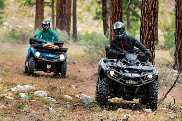 Two Can-Am Outlander vehicles in the forest