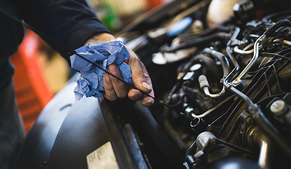 Close up hands of unrecognizable mechanic doing car service and maintenance. Oil and fuel filter changing.