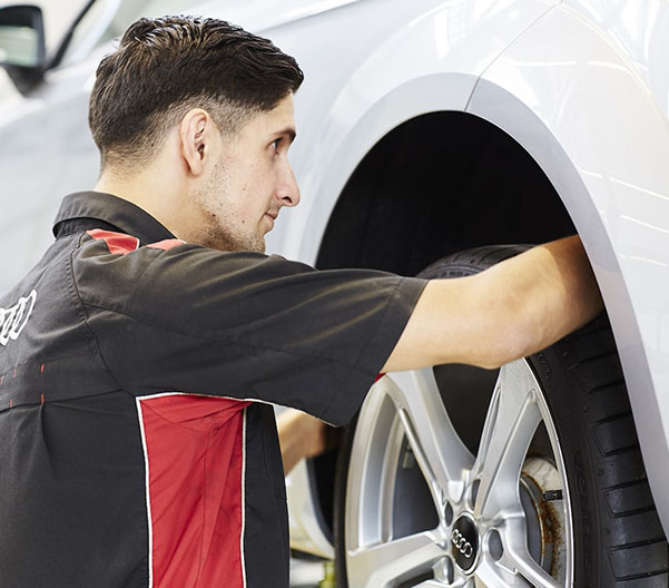 Audi service tech inspecting a vehicle