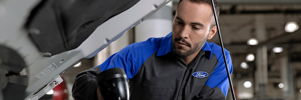 Ford service tech leaning over a vehicle
