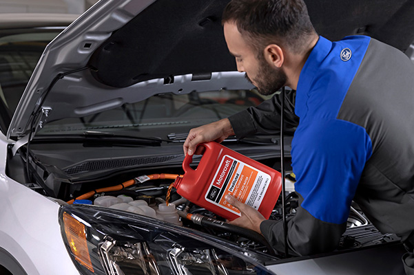 Ford service tech replacing fluids in a vehicle