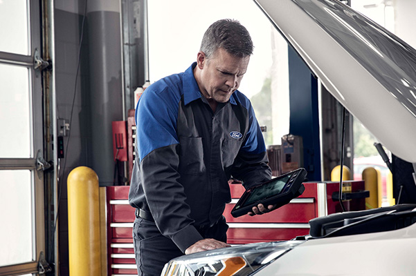 technician fixing examining a car