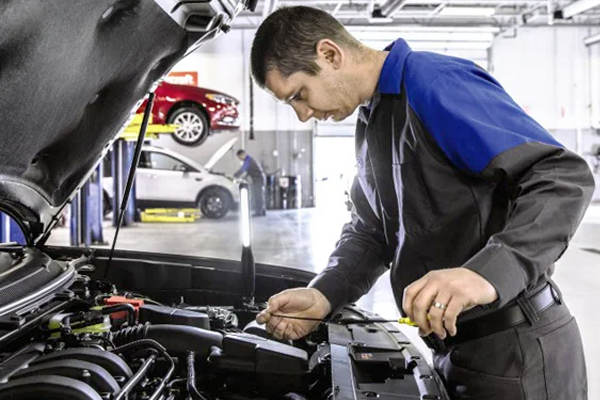 Ford service tech checking the oil level in a vehicle