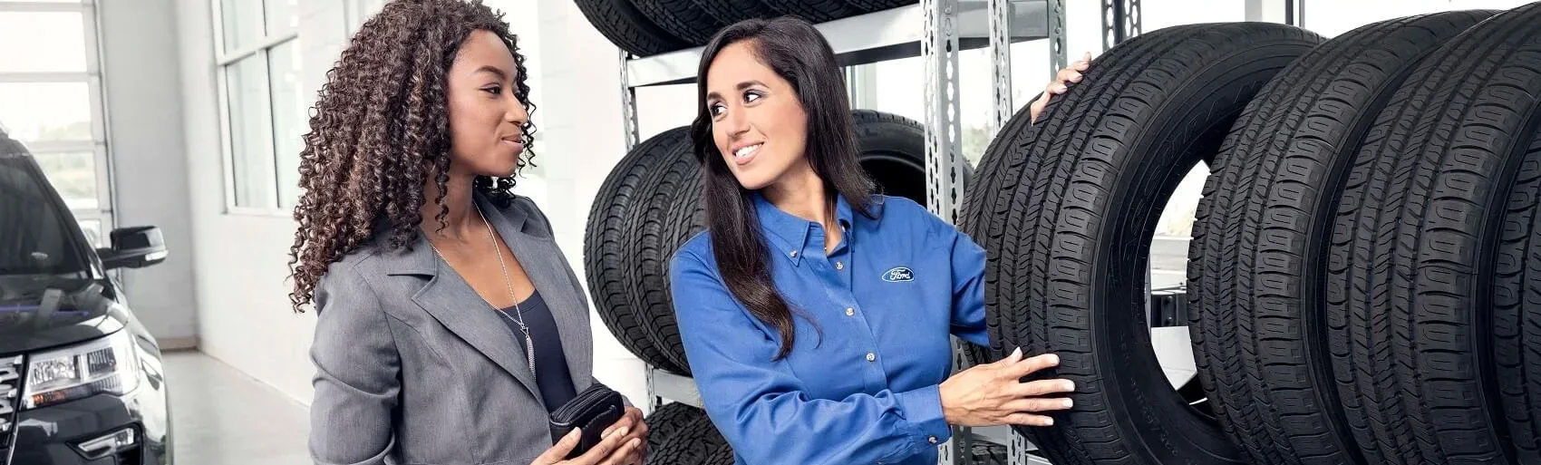 Ford parts employee showing a customer the tire inventory