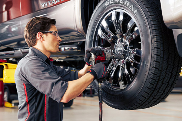 technician fixing the wheels on a new nissan