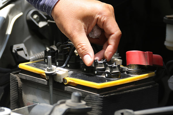 auto technician checking battery life with batt