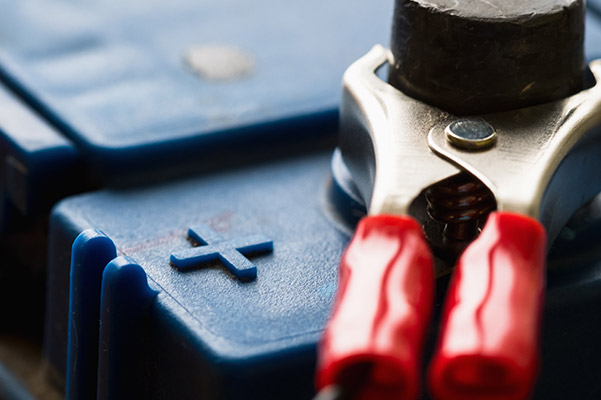 auto technician installing a new car battery on a car