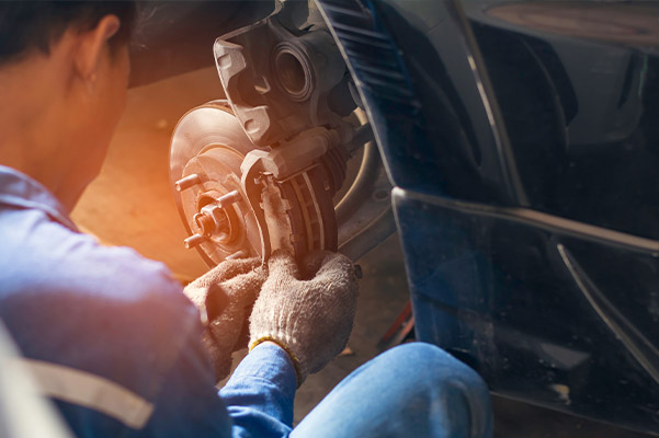 auto technician inspecting car brakes